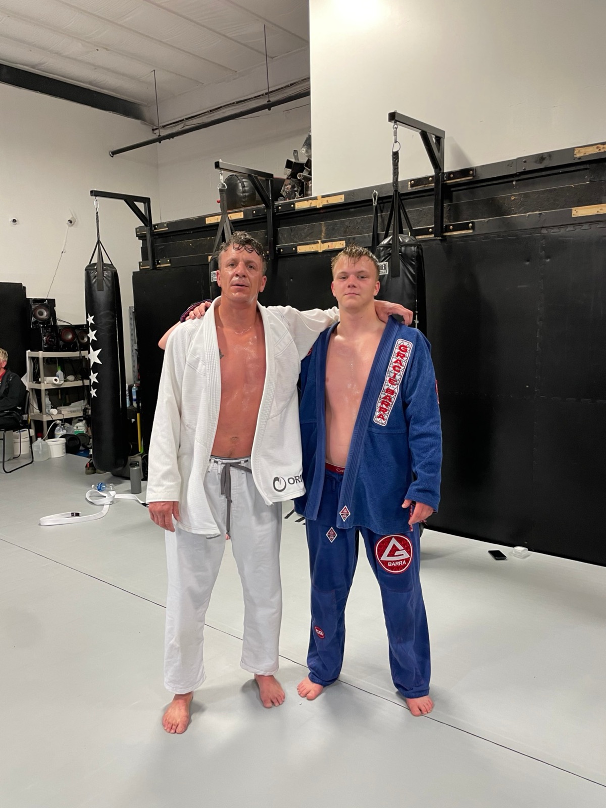 Philip Henry post-training in a BJJ gi with his son at the gym